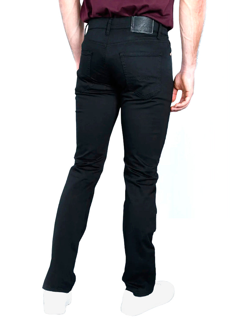 Hombre vistiendo pantalones jeans color negro de corte ajustado.