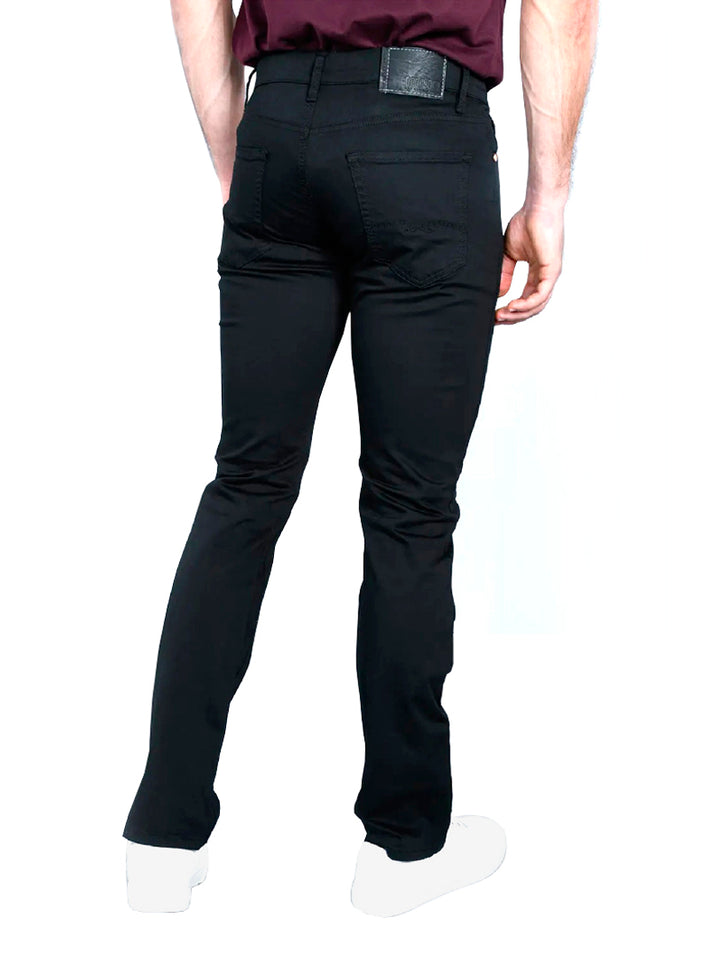 Hombre vistiendo pantalones jeans color negro de corte ajustado.