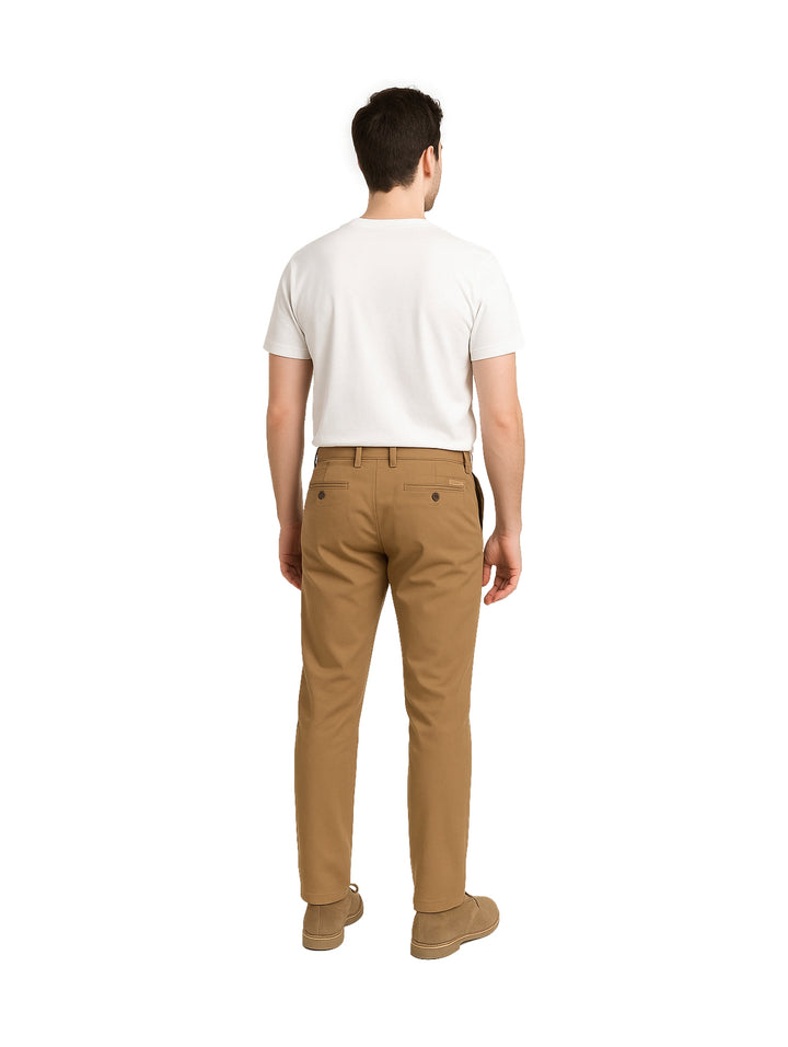 Hombre vistiendo un pantalón chino slim fit color tabaco con una playera blanca básica.