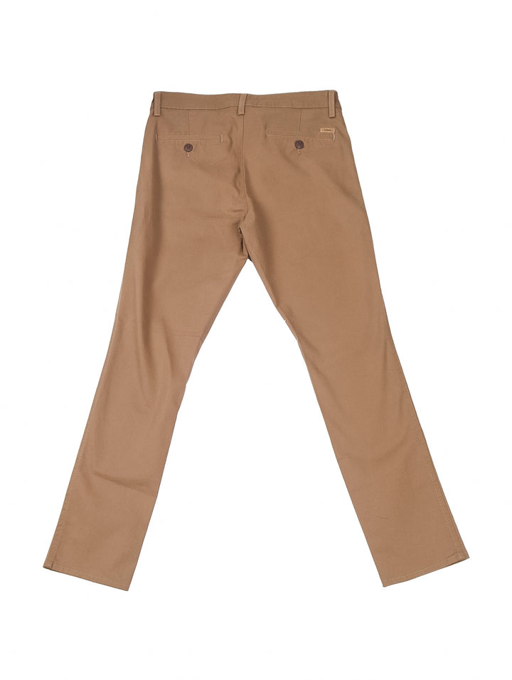 Hombre vistiendo un pantalón chino slim fit color tabaco con una playera blanca básica.
