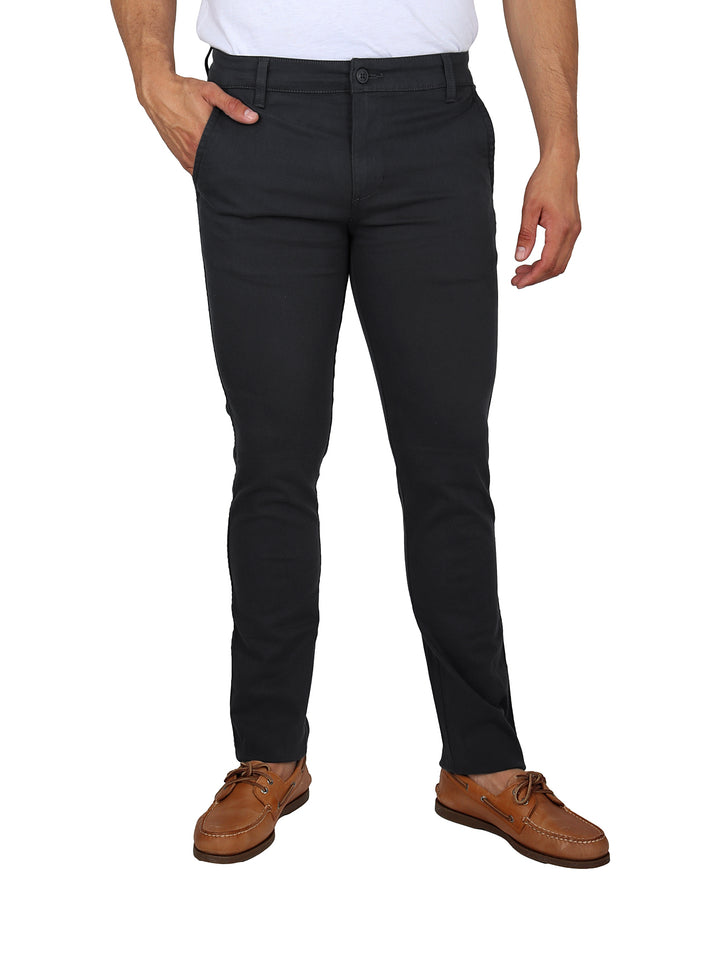 Hombre vistiendo pantalones OGGI Jeans Basic color New Oxford y zapatos cafés.