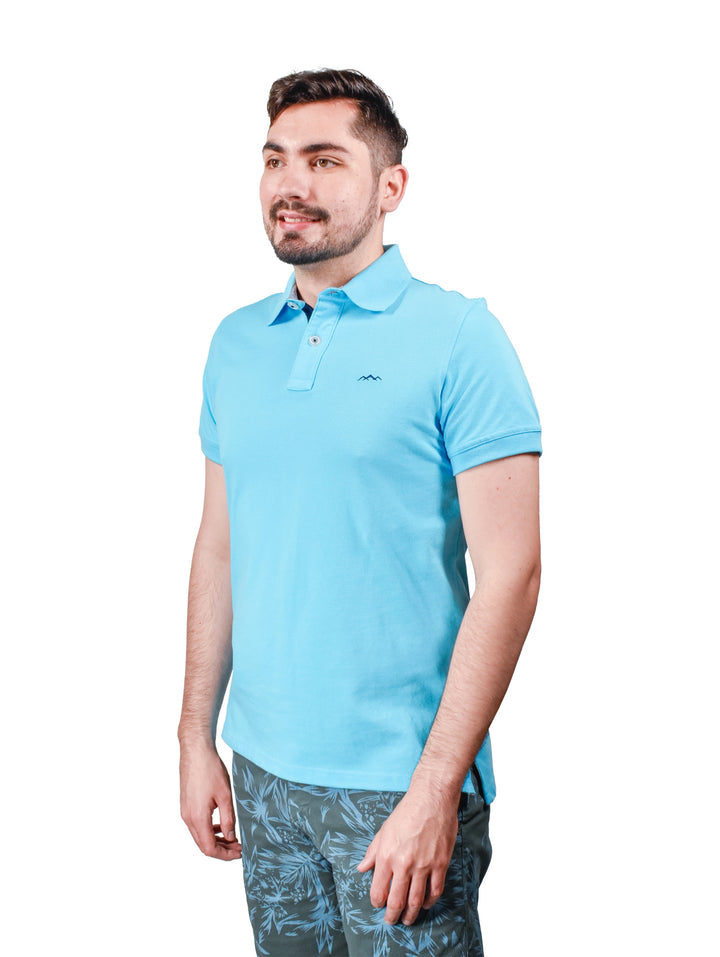 Hombre vistiendo playera polo de color esmeralda de la marca White Peak.