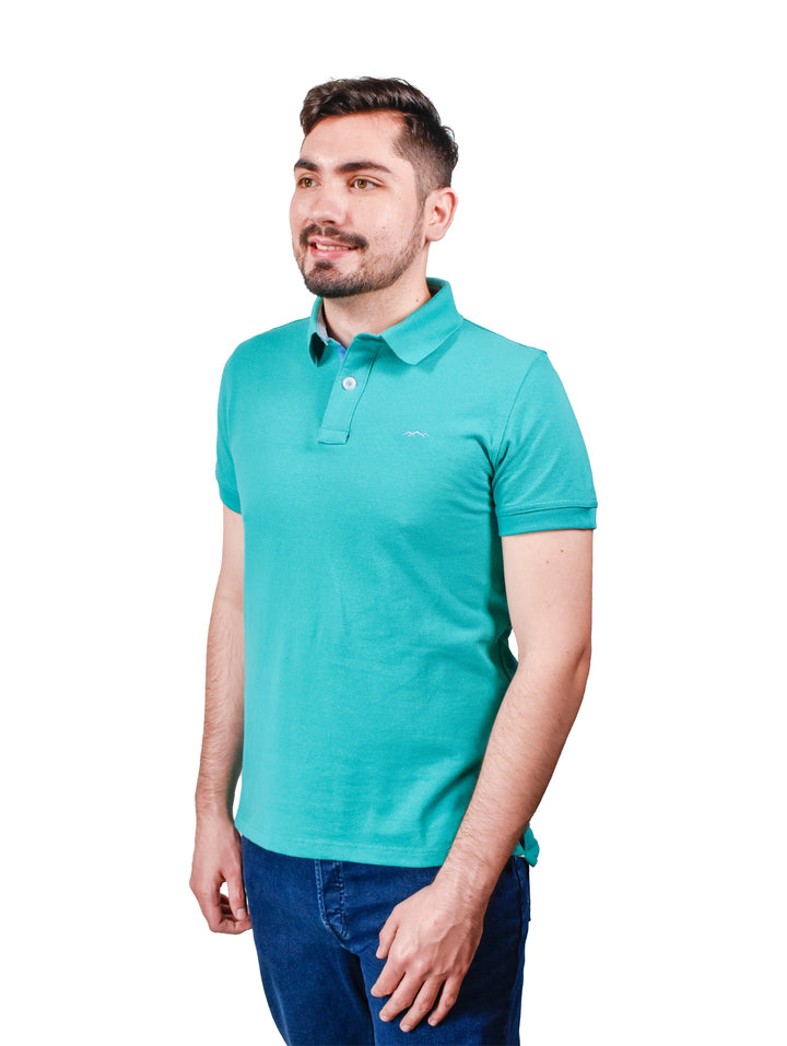 Hombre vistiendo una playera polo color azul aqua de manga corta.