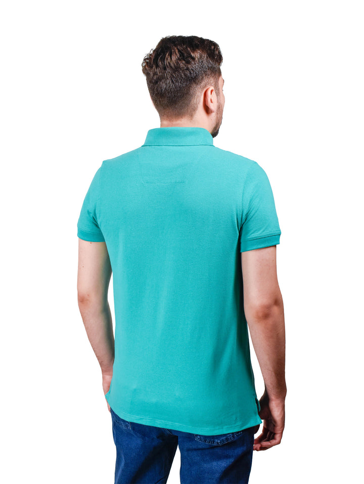 Hombre vistiendo una playera polo color azul aqua de manga corta.