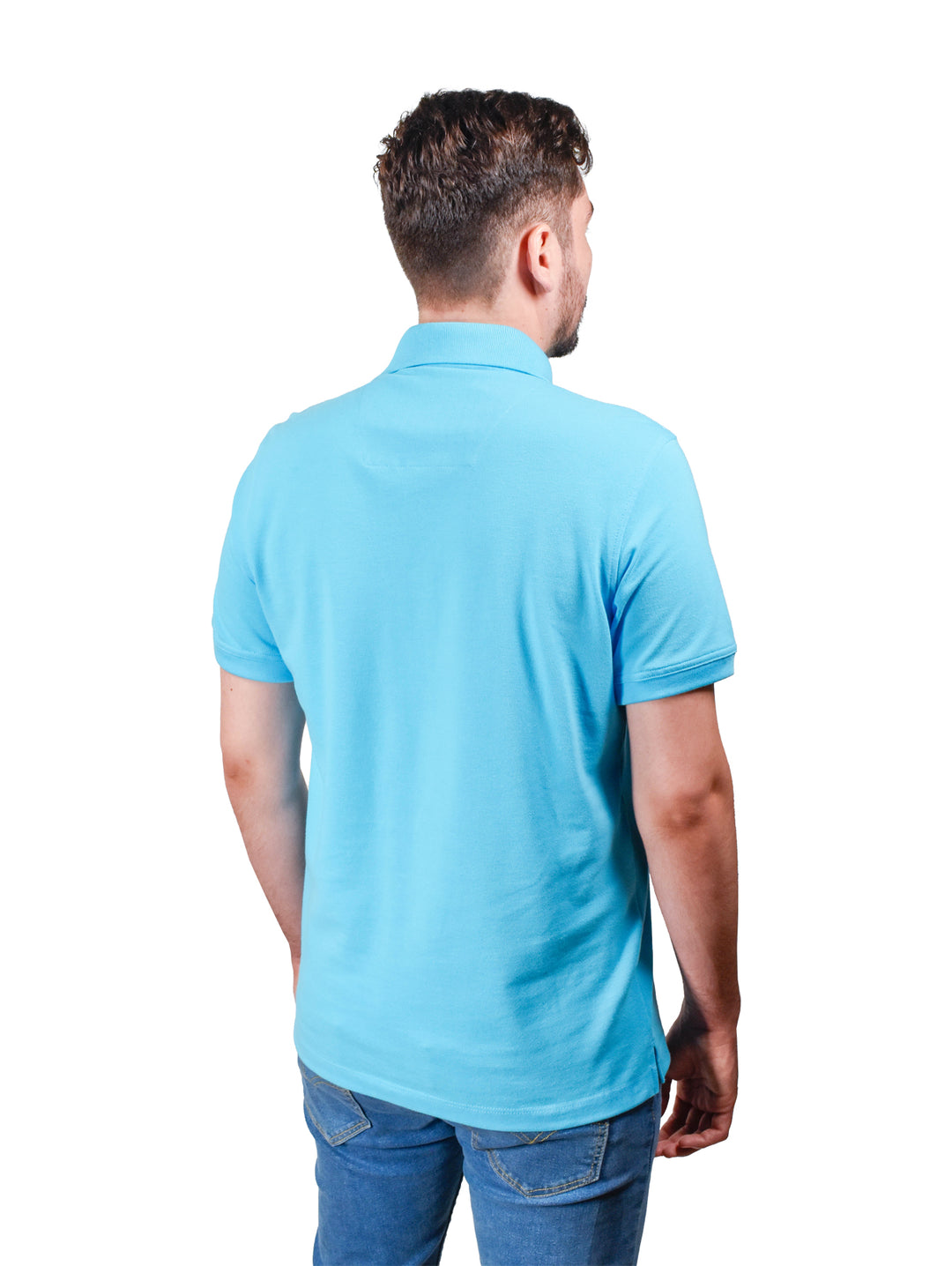 Hombre vistiendo playera polo color azul aqua con cuello estampado y pantalones vaqueros azules.