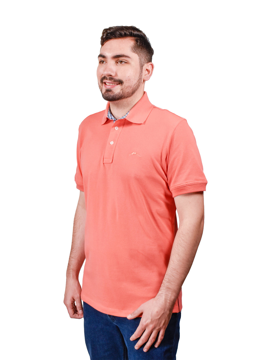 Hombre vistiendo una playera polo color coral de manga corta con detalle en el cuello.