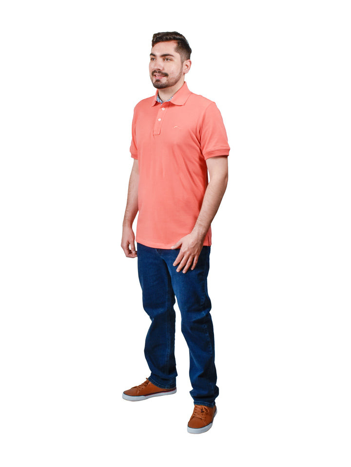 Hombre vistiendo una playera polo color coral de manga corta con detalle en el cuello.