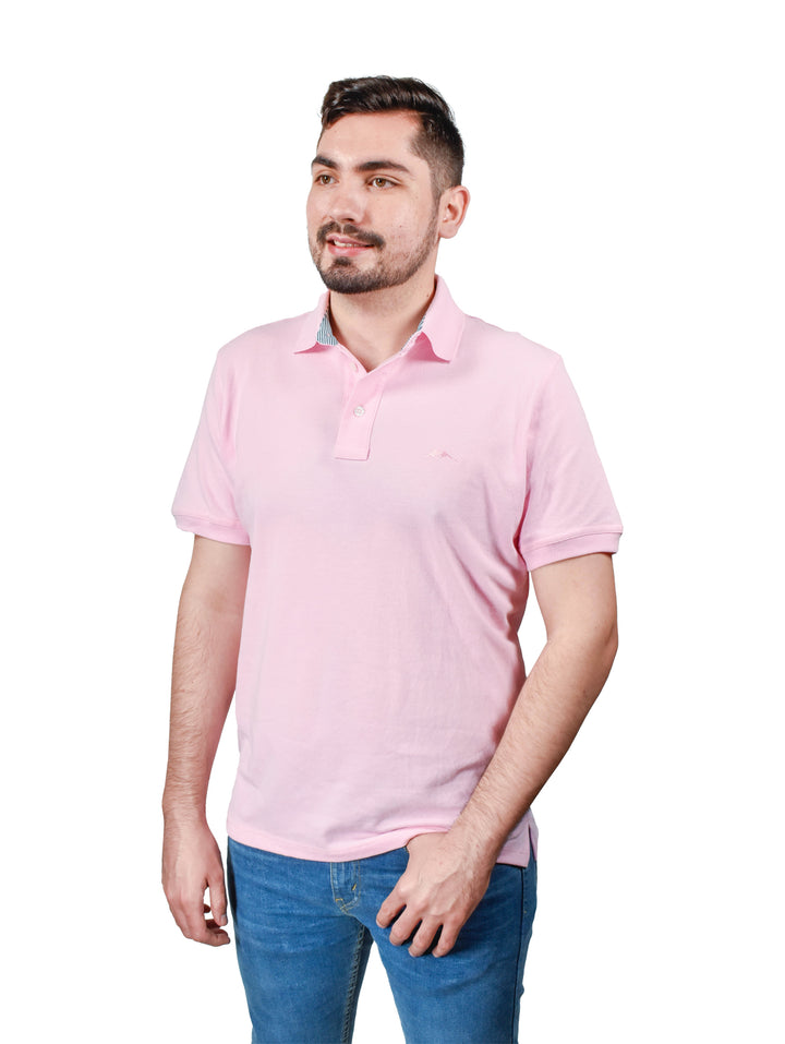 Hombre usando una playera polo color rosa de manga corta y cuello con botones.