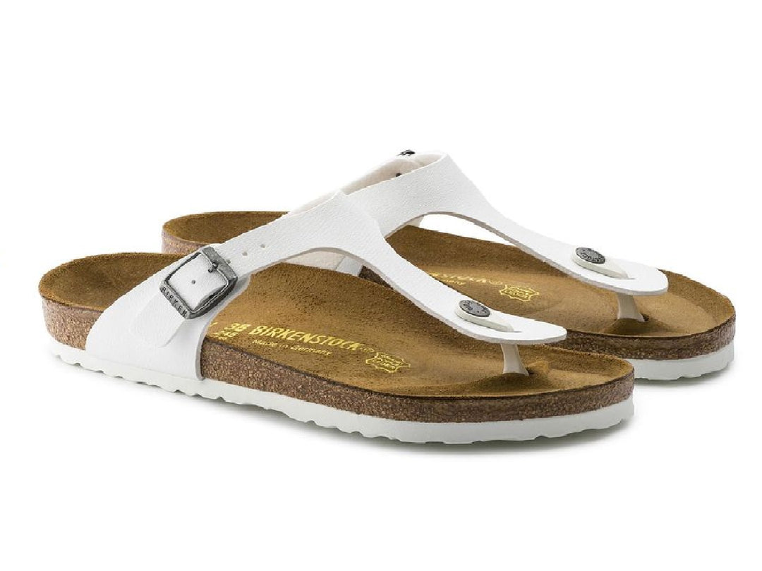 Sandalia blanca Birkenstock para mujer con plantilla de corcho y hebilla metálica.