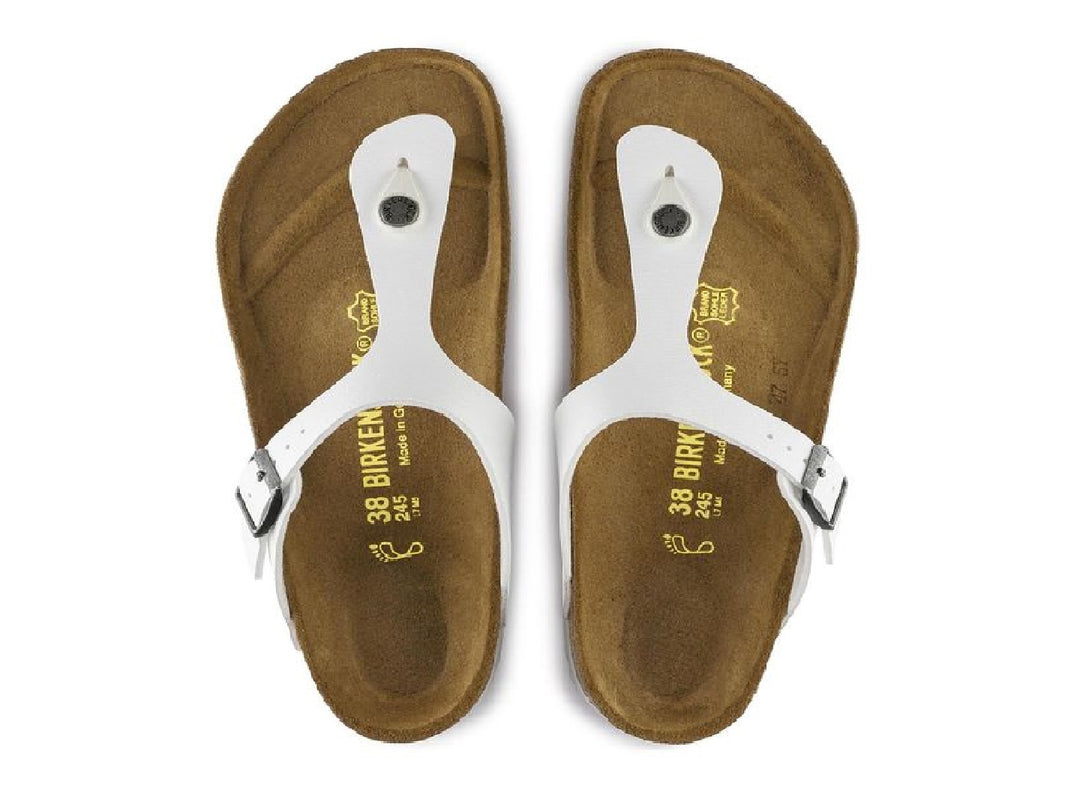 Sandalia blanca Birkenstock para mujer con plantilla de corcho y hebilla metálica.