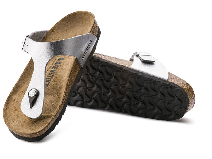 Sandalia Birkenstock Gizeh en color plata metálico con suela de corcho y correa ajustable con hebilla.
