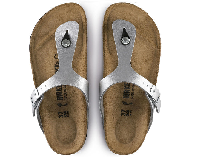 Sandalia Birkenstock Gizeh en color plata metálico con suela de corcho y correa ajustable con hebilla.