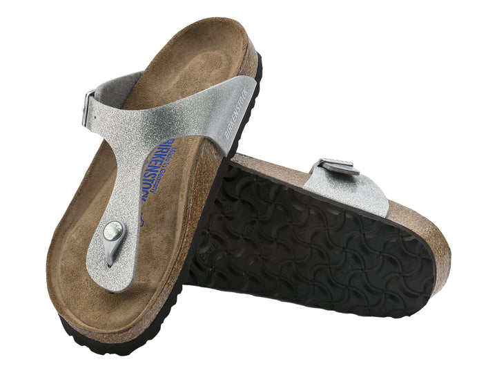 Sandalia Birkenstock Gizeh en color plata brillante con suela de corcho y correa ajustable.