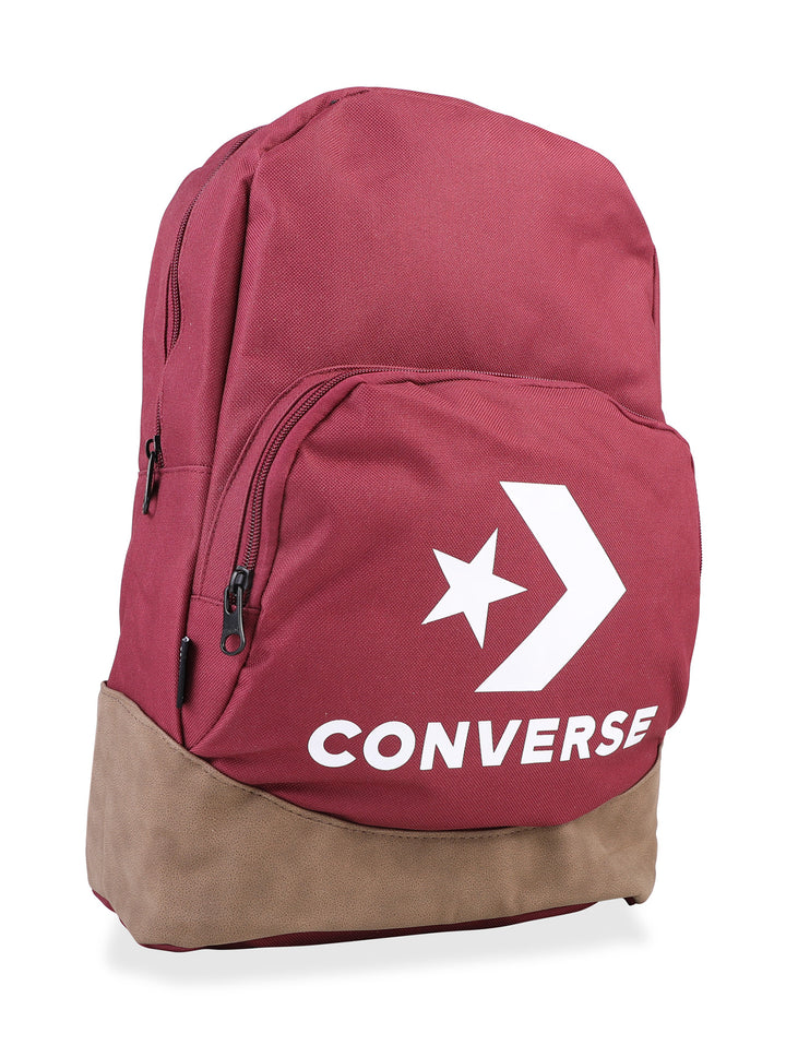 Mochila escolar Converse color vino con base café y logotipo blanco frontal.