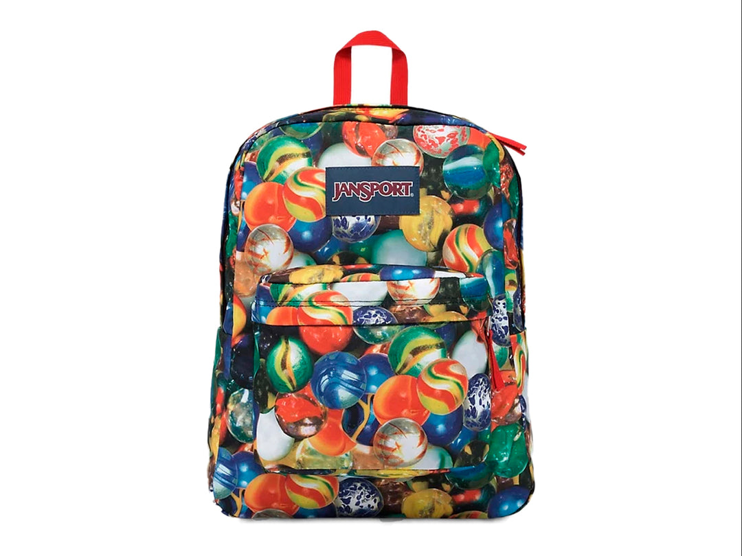 Mochila escolar JanSport con estampado multicolor de canicas y asa superior roja.