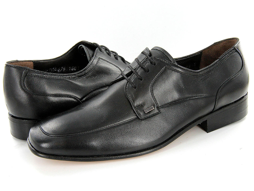 Par de zapatos formales color negro de cuero con cordones sobre fondo blanco.