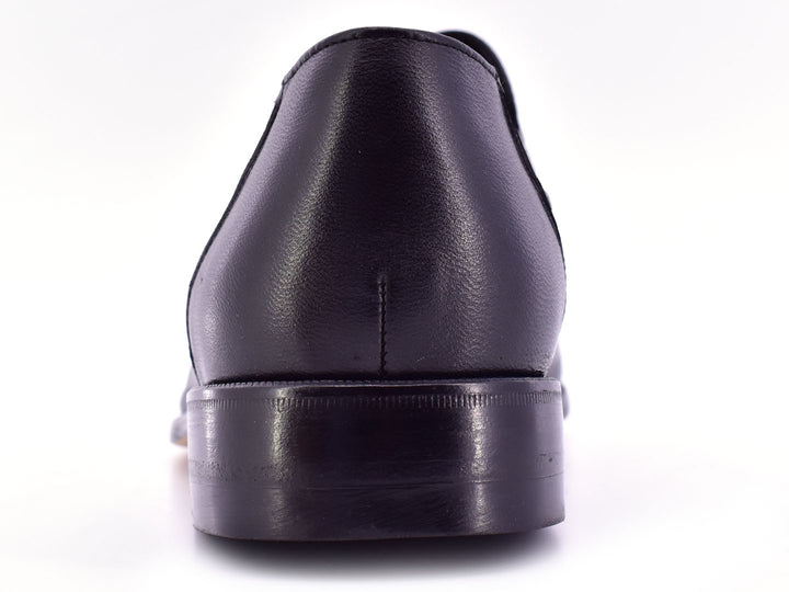 Par de zapatos planos negros de cuero con textura combinada, estilo elegante y sin cordones.