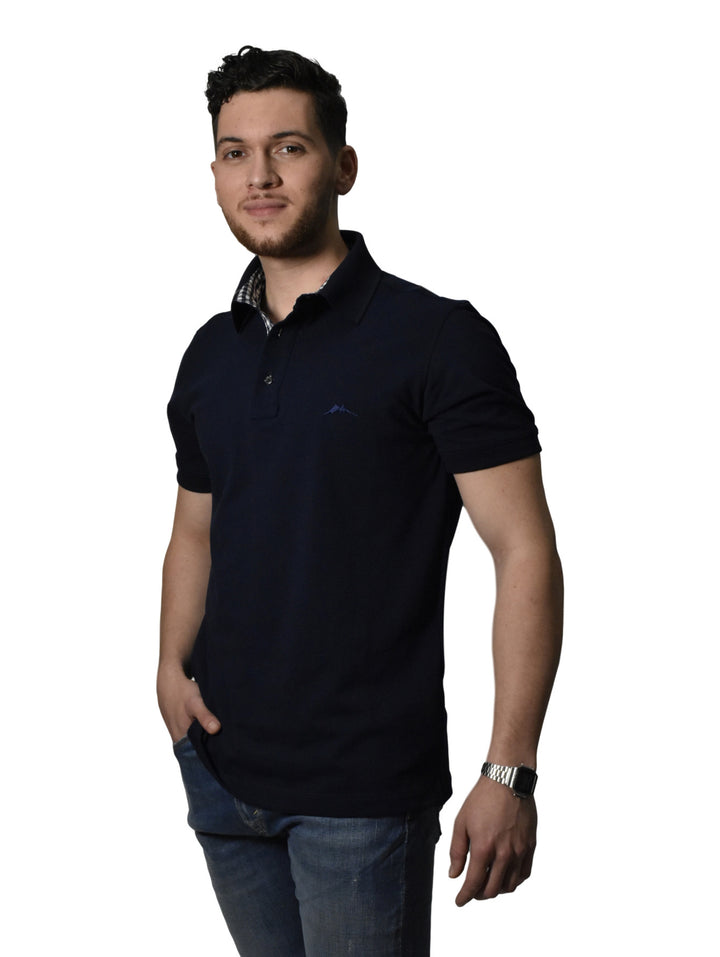 Hombre vistiendo una camiseta polo color marino de la marca WHITE PEAK con cuello estampado.