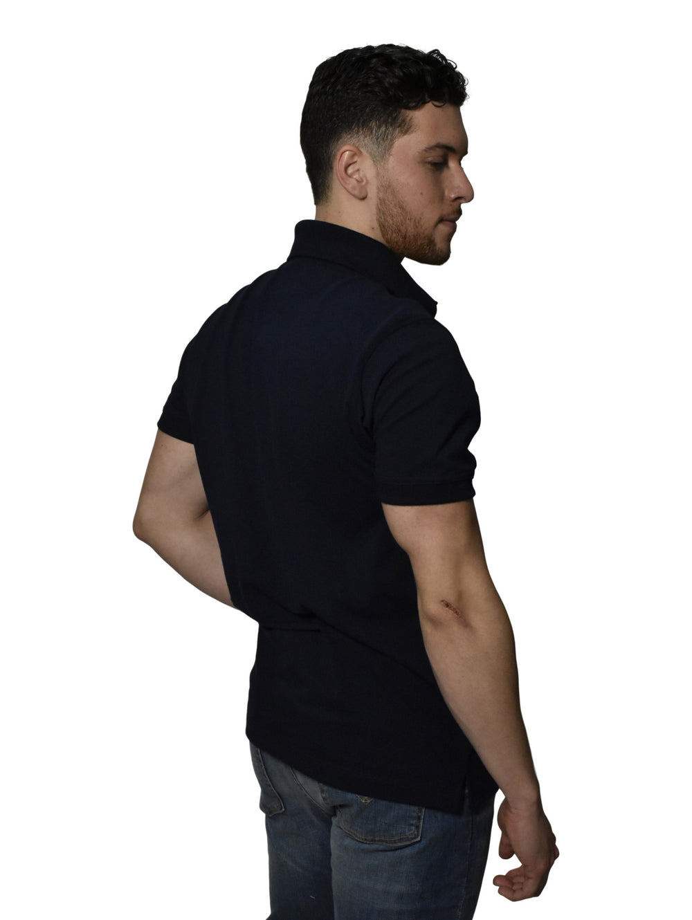 Hombre vistiendo una camiseta polo color marino de la marca WHITE PEAK con cuello estampado.