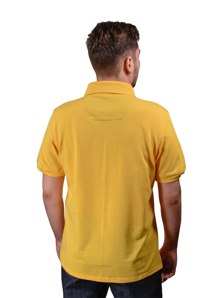 Hombre vistiendo playera polo color amarillo canario de manga corta.
