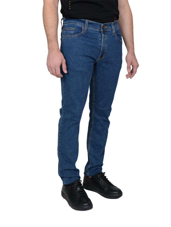 Hombre vistiendo pantalones jeans azules de corte ajustado y calzado negro.
