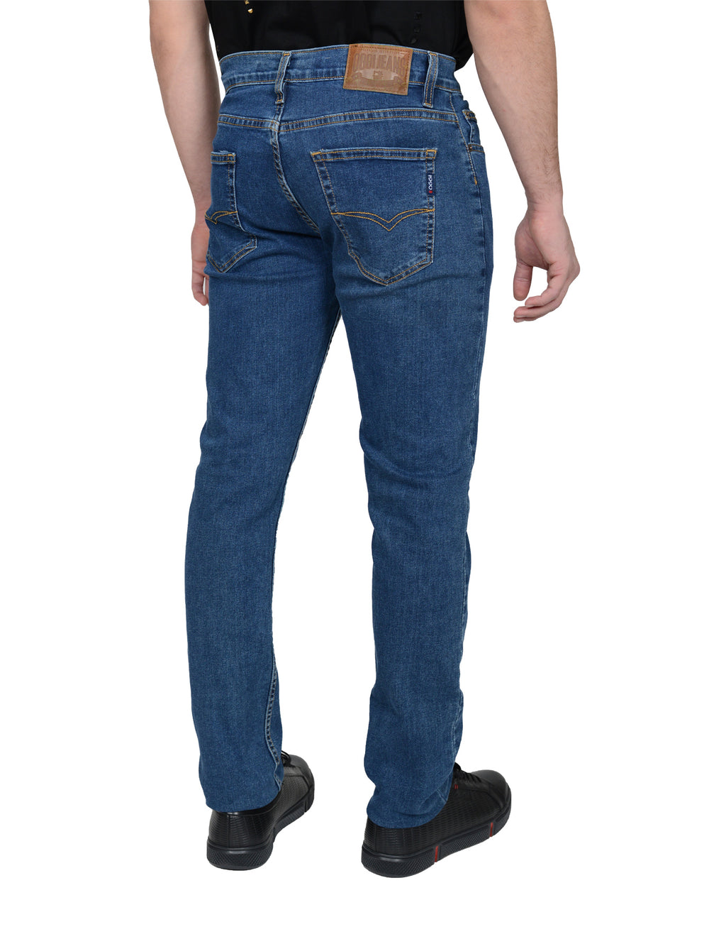 Hombre vistiendo pantalones jeans azules de corte ajustado y calzado negro.