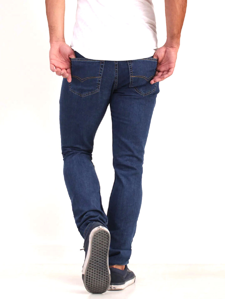 Hombre vistiendo jeans OGGI de color azul oscuro con corte ajustado.
