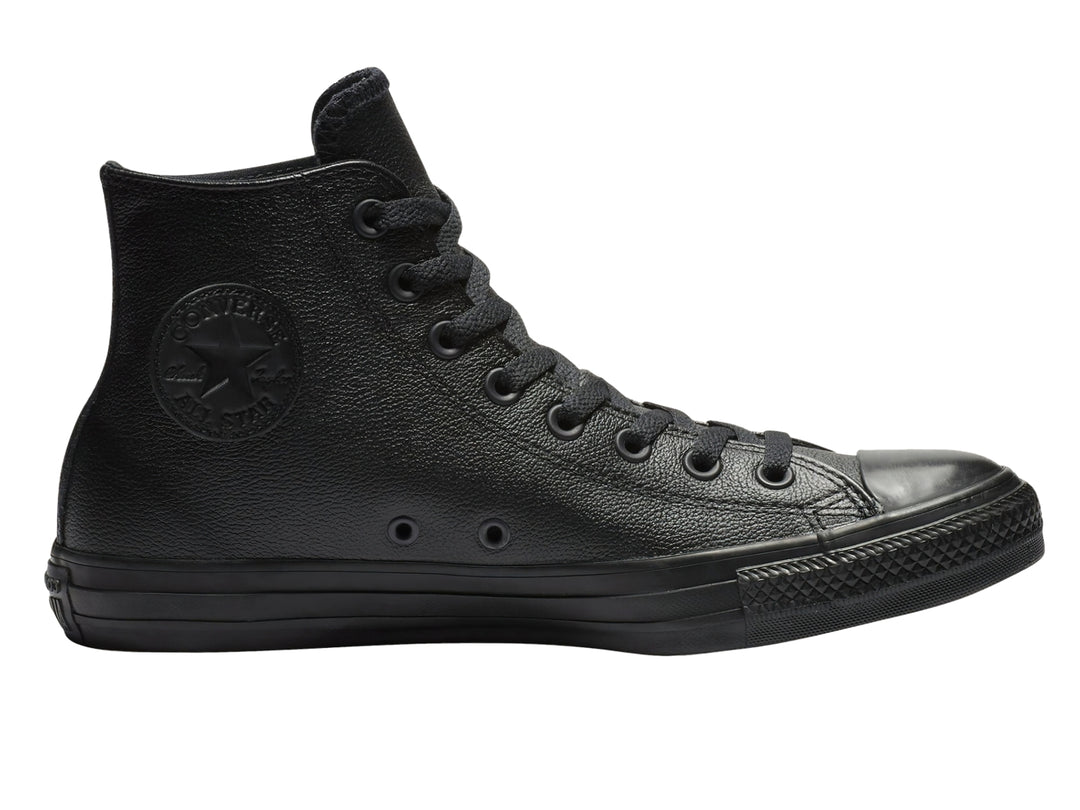 Tenis Converse Chuck Taylor de cuero negro, modelo bota con agujetas y suela negra.