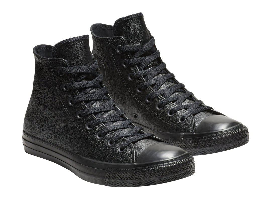 Tenis Converse Chuck Taylor de cuero negro, modelo bota con agujetas y suela negra.