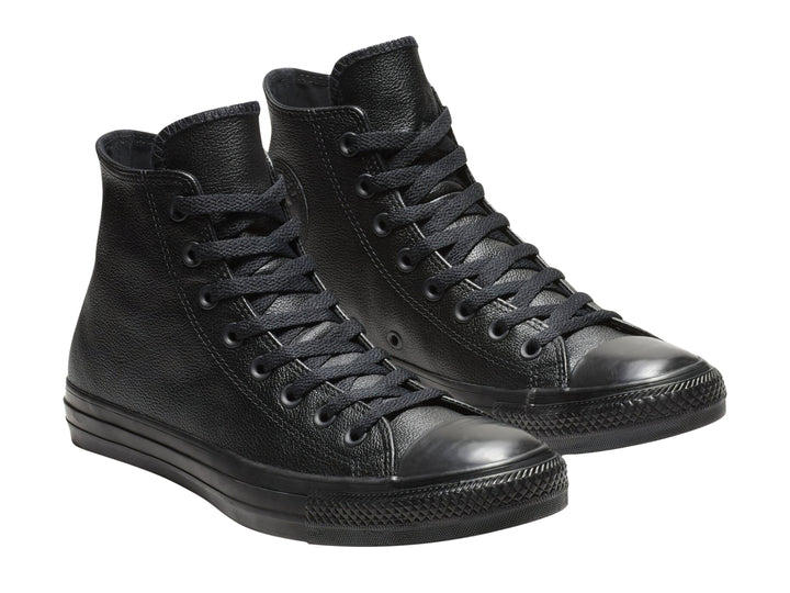 Tenis Converse Chuck Taylor de cuero negro, modelo bota con agujetas y suela negra.