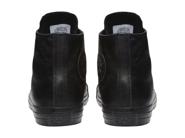Tenis Converse Chuck Taylor de cuero negro, modelo bota con agujetas y suela negra.