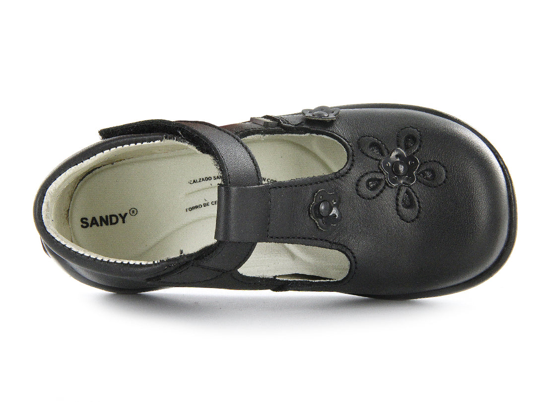 Par de zapatos negros para niña con correa de velcro y detalles de flores en relieve sobre el empeine.