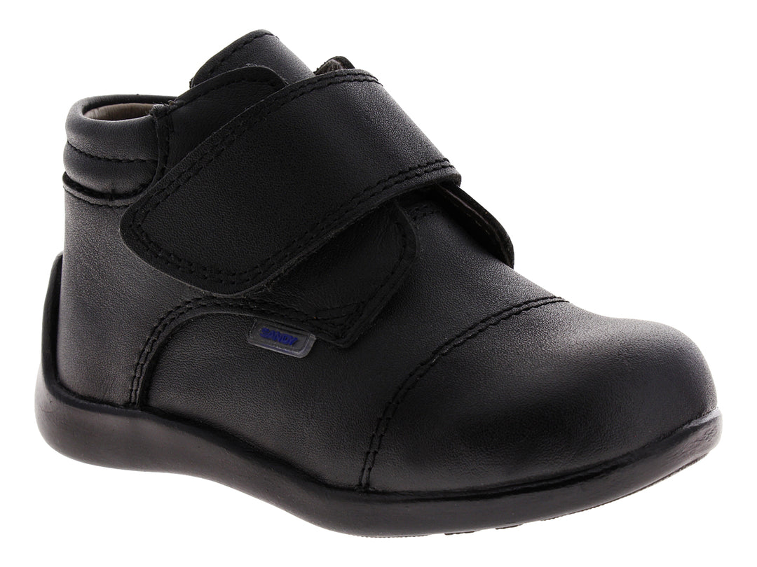 Zapato infantil de color negro con cierre de velcro.