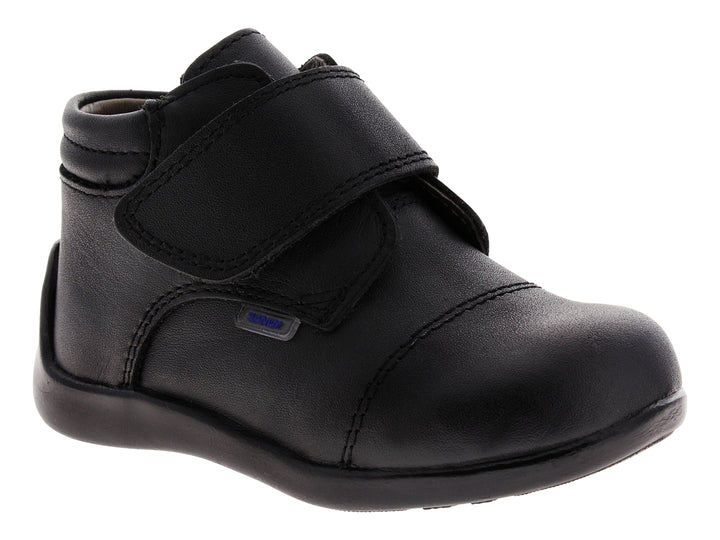 Zapato infantil de color negro con cierre de velcro.
