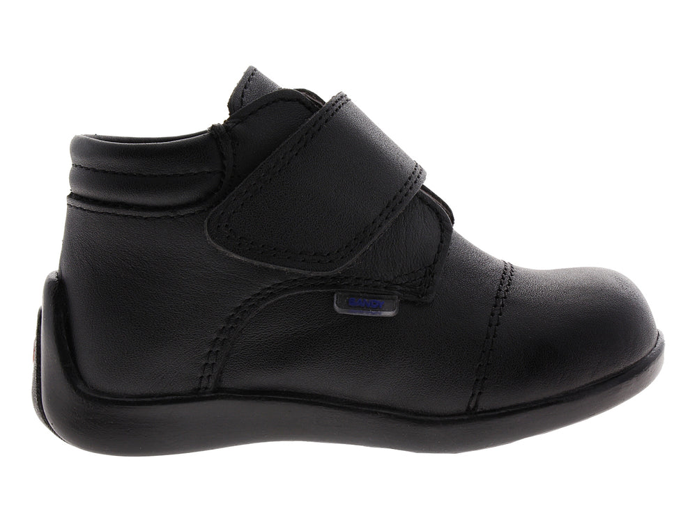 Zapato infantil de color negro con cierre de velcro.
