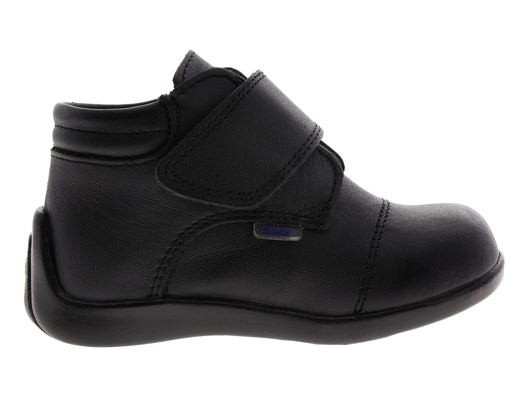 Zapato infantil de color negro con cierre de velcro.