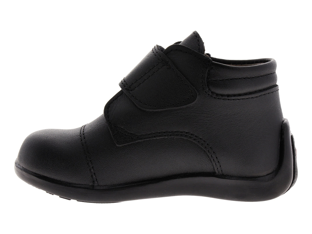 Zapato infantil de color negro con cierre de velcro.