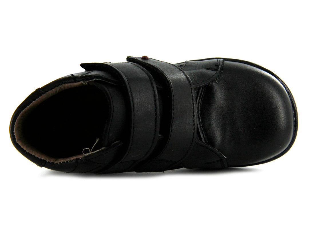 Par de zapatos negros para niño de material sintético o cuero con cierre de doble correa de velcro.