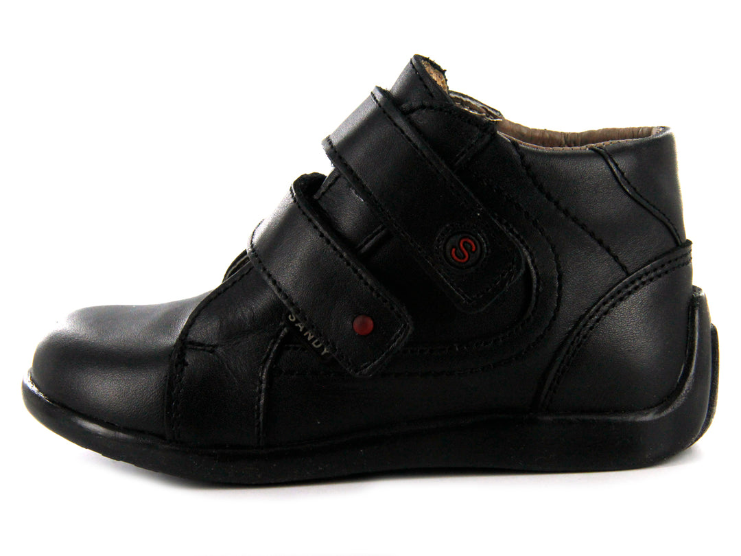 Par de zapatos negros para niño con cierre de doble correa de velcro y suela negra.