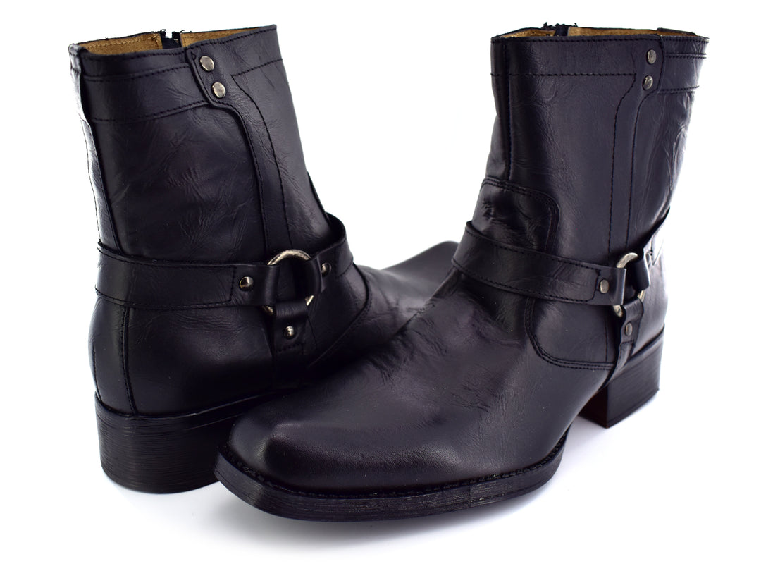 Botines negros para hombre con hebilla y remaches plateados sobre fondo blanco.