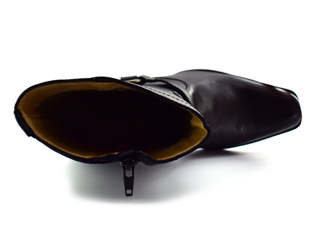 Botines negros para hombre con hebilla y remaches plateados sobre fondo blanco.