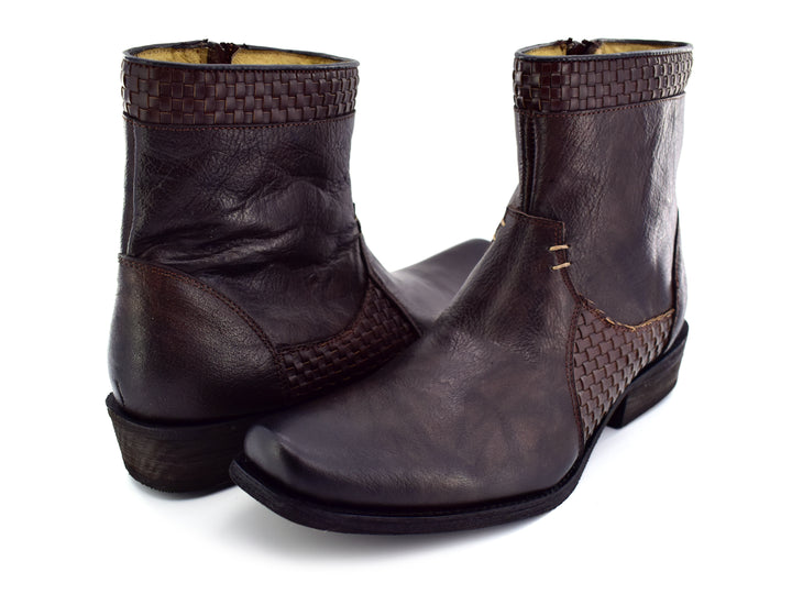 Par de botas para hombre de cuero color café con detalles trenzados en el tobillo y lateral.