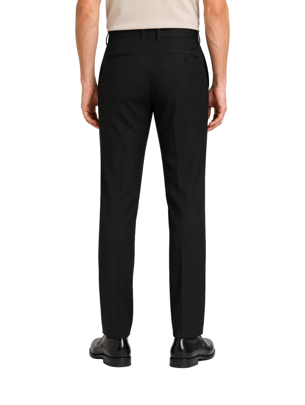 Hombre vistiendo un pantalón formal de color negro y zapatos negros sobre fondo blanco.