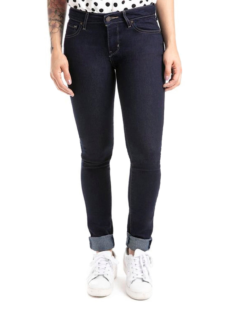 Vista lateral de mujer usando jeans Levi's 711 skinny color azul oscuro y tenis blancos.