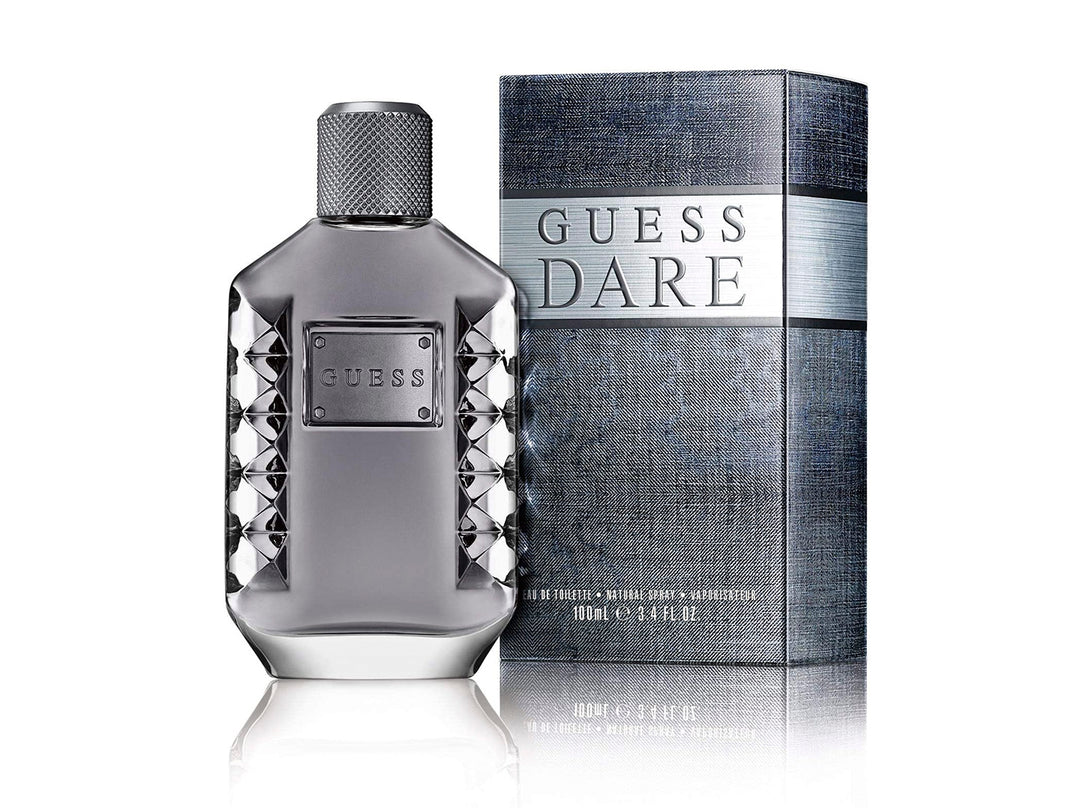 Botella de perfume Guess Dare para hombre en color gris oscuro junto a su caja azul texturizada.