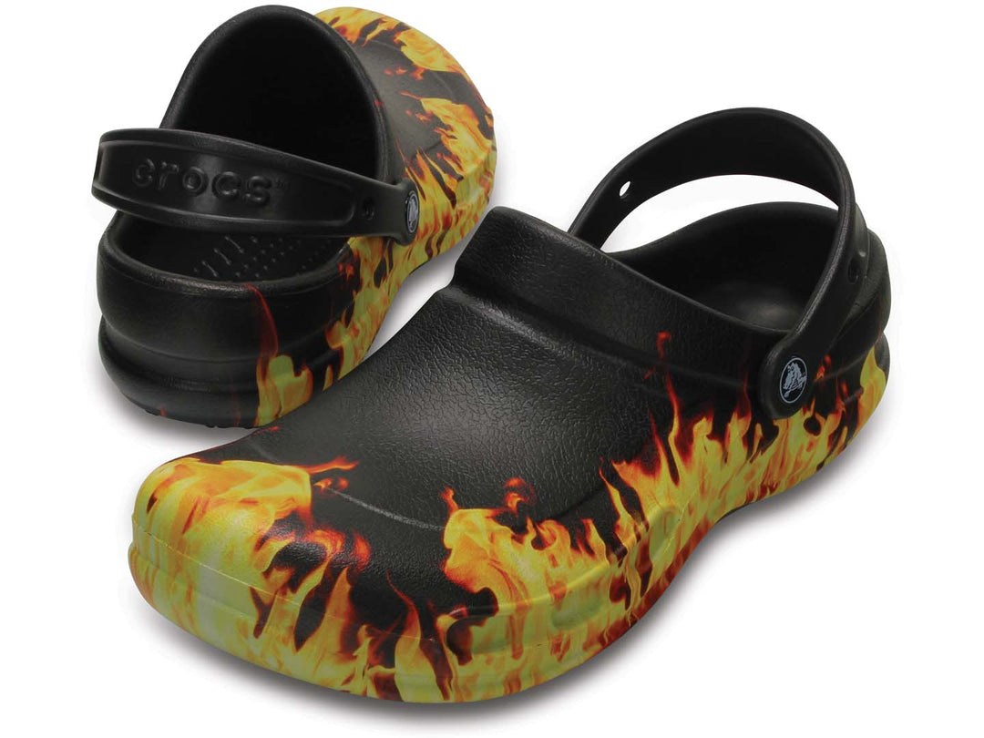 Zuecos Crocs Bistro negros con diseño de llamas en colores amarillo y naranja.
