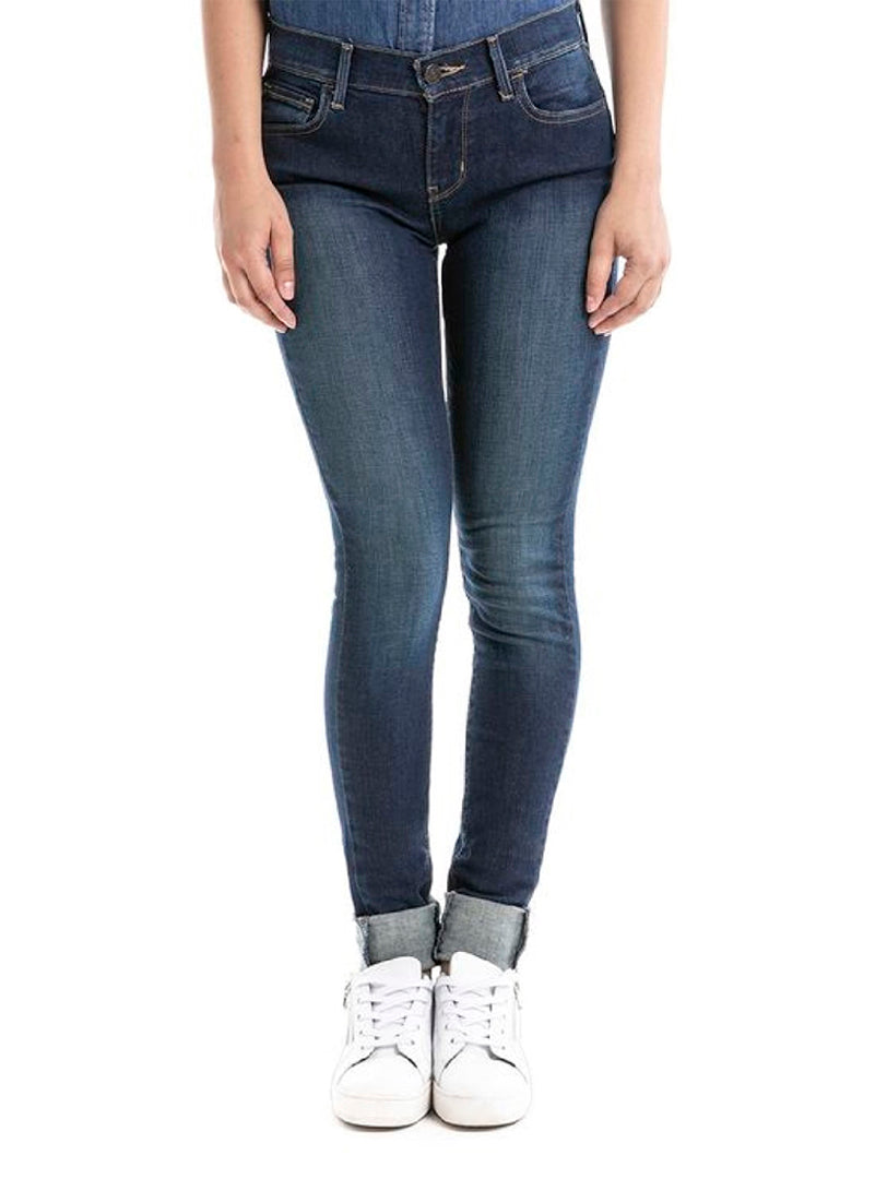 Mujer modelando jeans Levi's 710 Super Skinny color indigo ridge con camisa de mezclilla y tenis blancos.