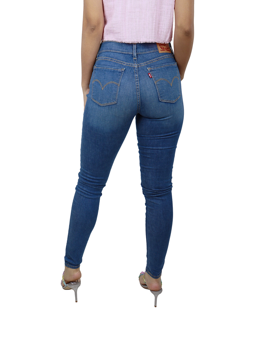 Vista trasera de mujer usando jeans Levi's 710 Super Skinny color azul.