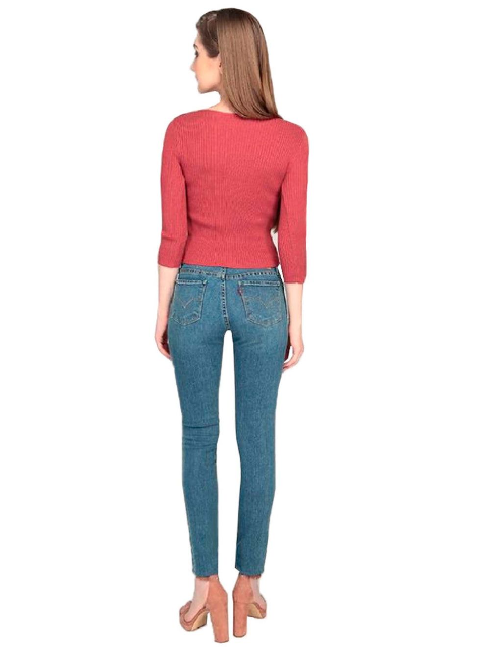 Mujer vistiendo jeans Levi's 711 skinny color azul índigo y un suéter rojo.