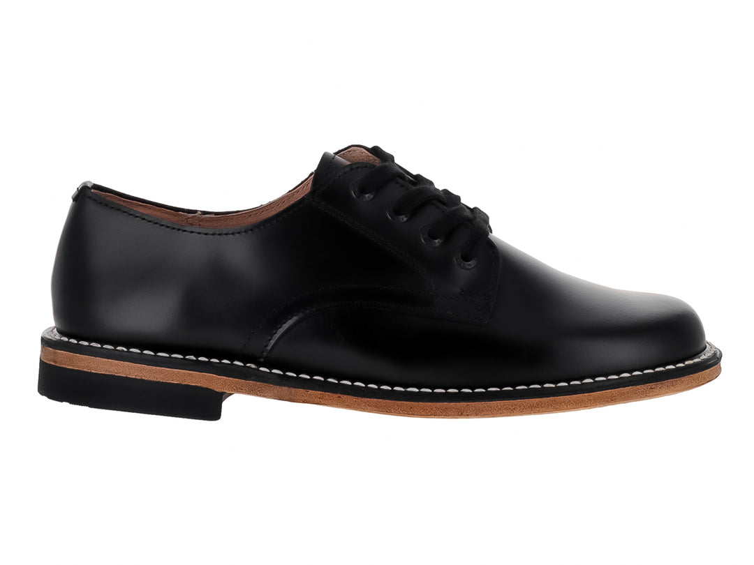 Zapato formal para niño de piel color negro con cordones y suela en tono café.